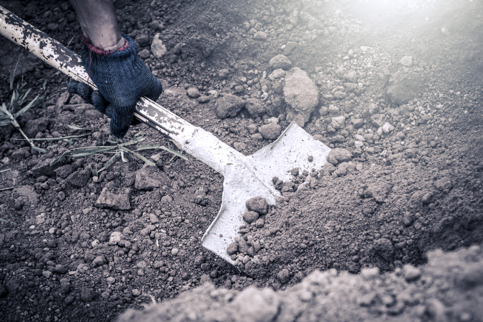 man hand shoveling the soil on garden,vintage filter